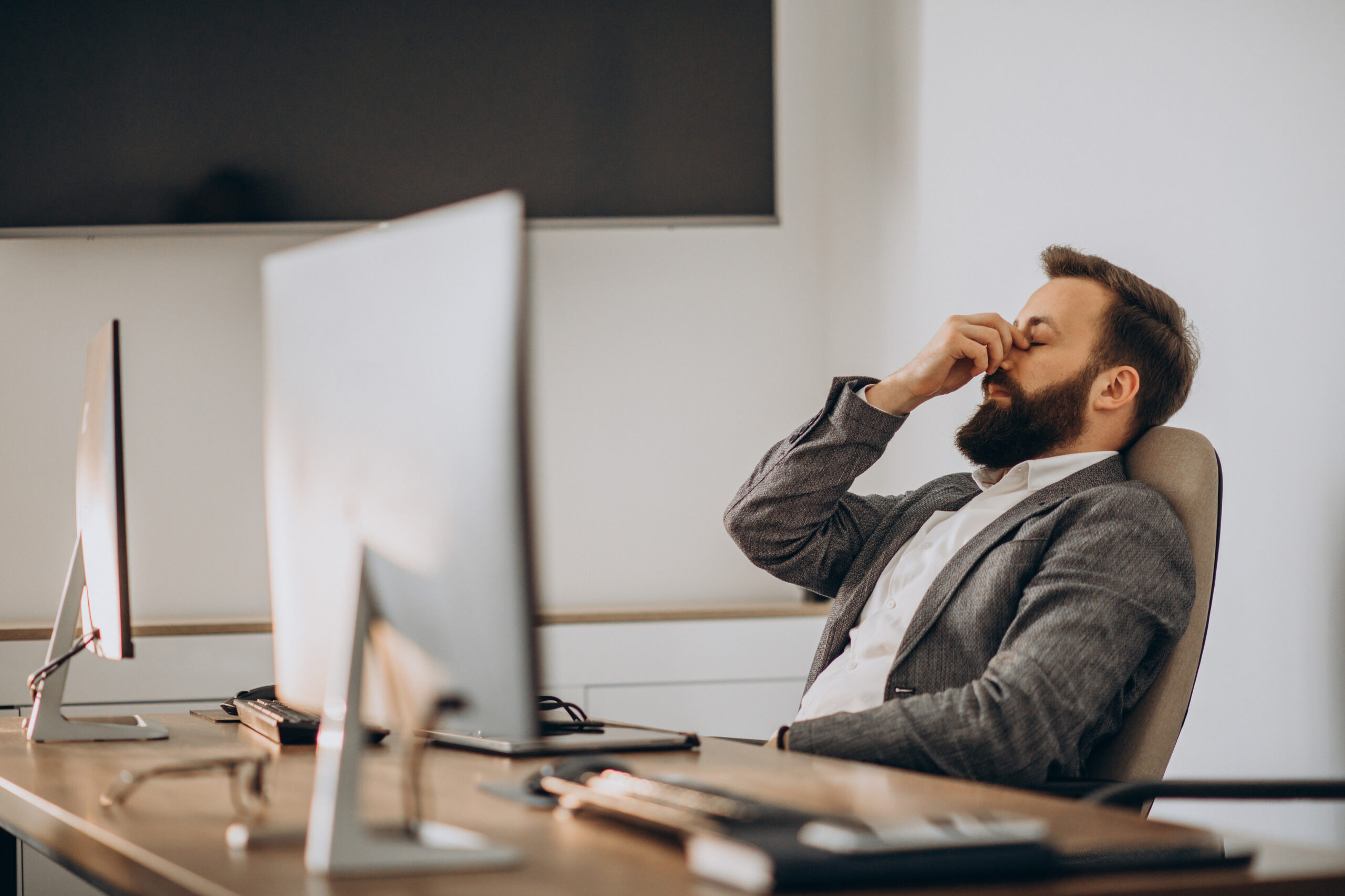 Homem com sinais de cansaço e sonolência no ambiente de trabalho, indicando possível distúrbio do sono ou apneia do sono. Homem com sinais de cansaço e sonolência no ambiente de trabalho, indicando possível distúrbio do sono ou apneia do sono.